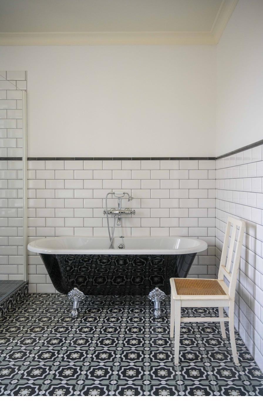 Bathroom with black clawfoot bath and cement tiles