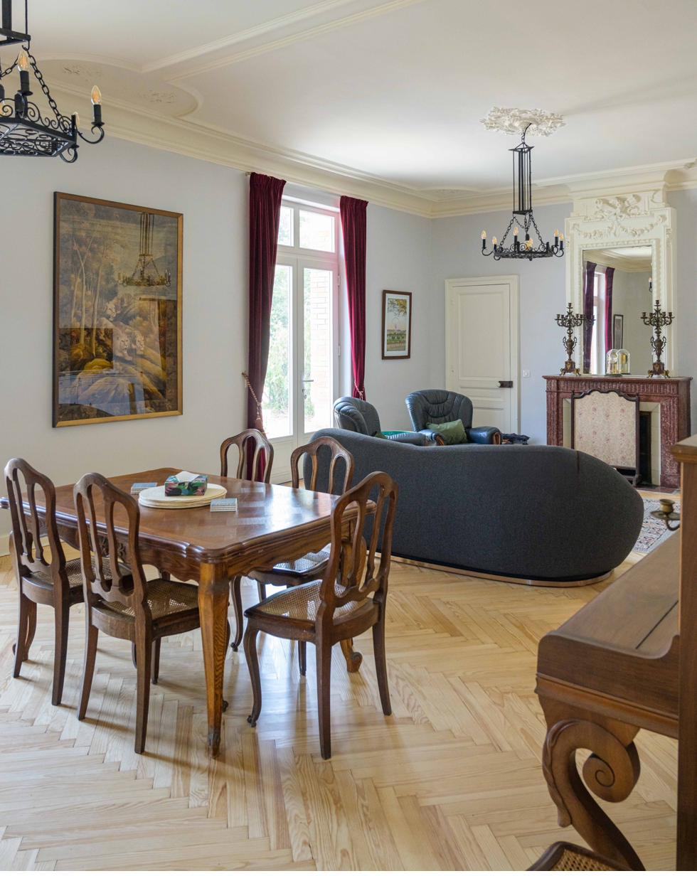 Lounge and dining room with herringbone parquet and chandeliers